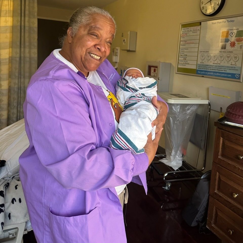 Una doula MHN sosteniendo un recién nacido en el hospital