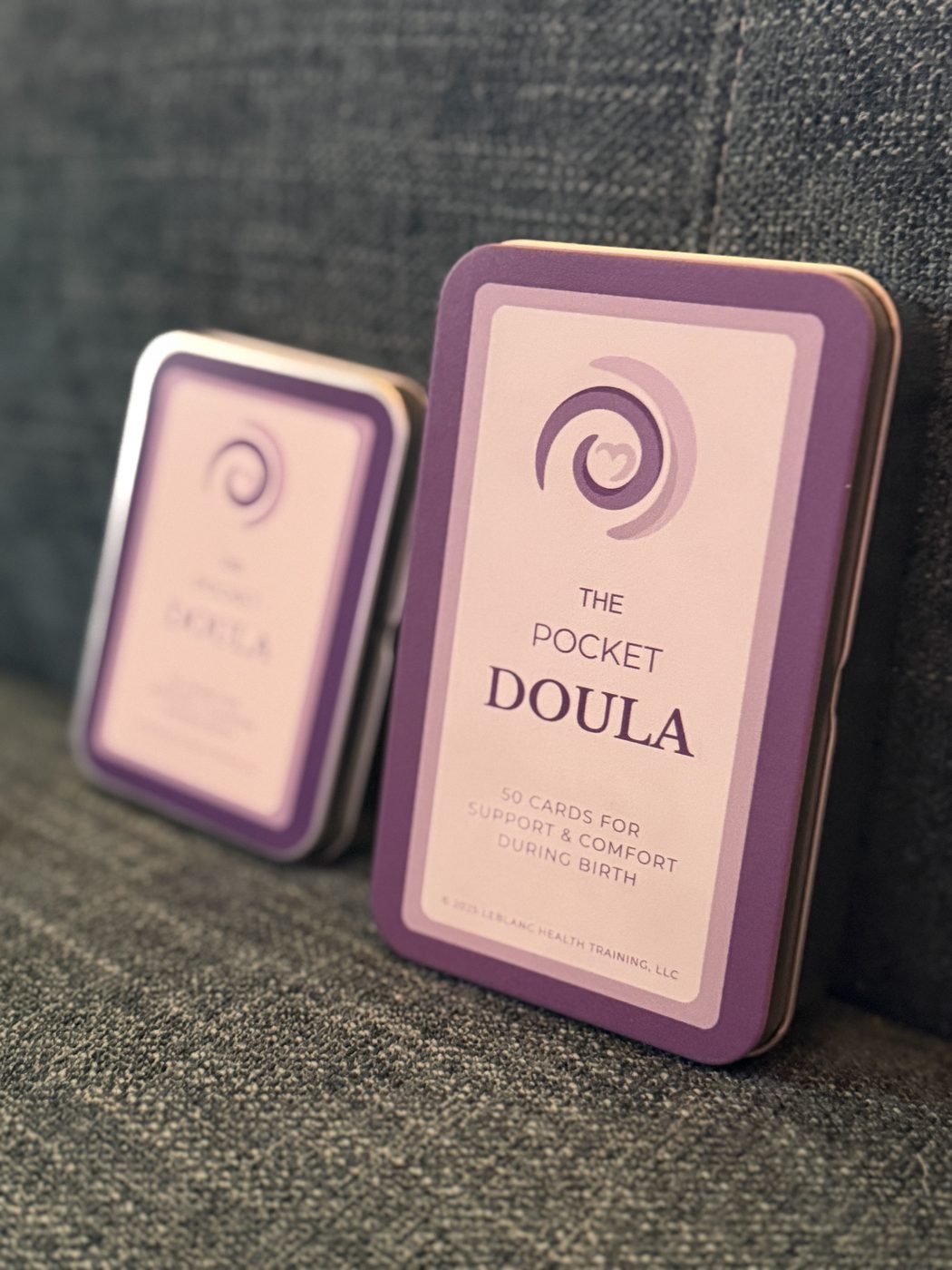 The Pocket Doula tin front-facing on textured fabric