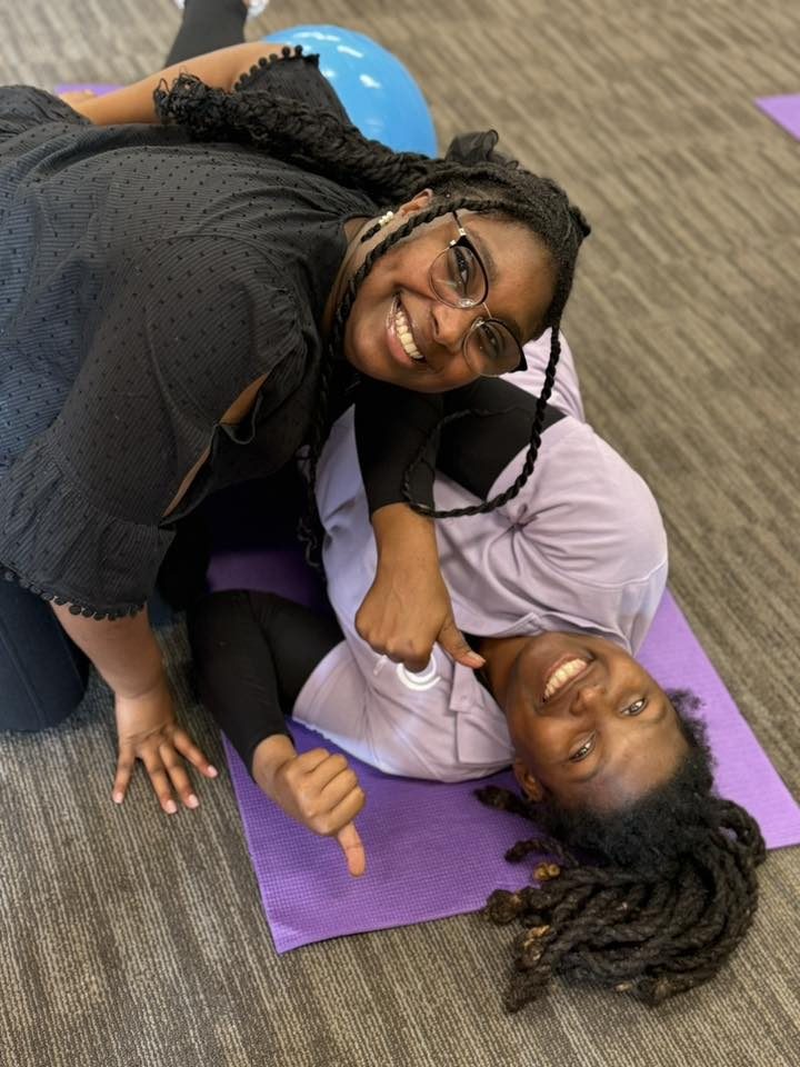 Two MHN doulas in training, joyful on the practice mat