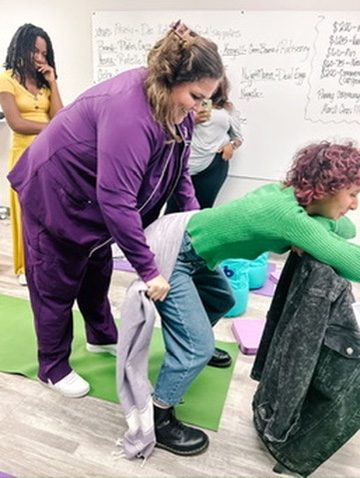 Madeline LeBlanc demonstrating rebozo technique to a trainee